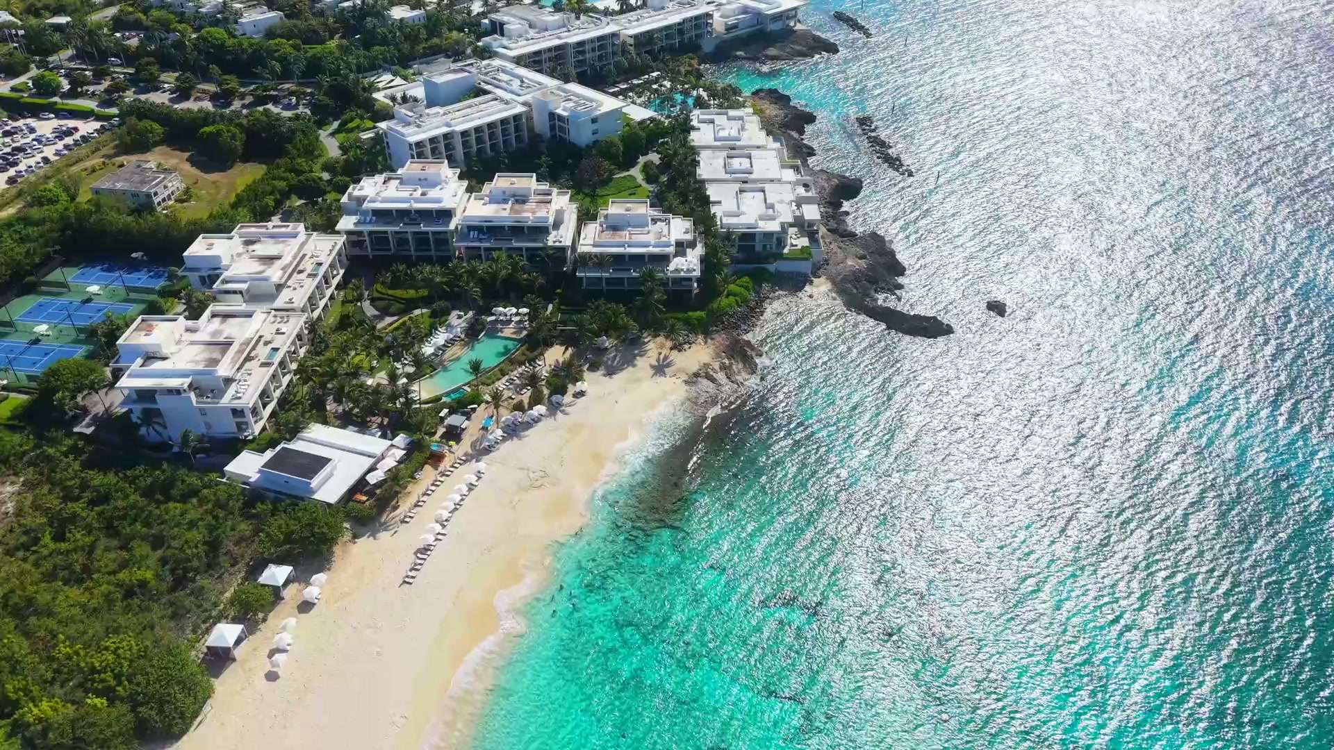 A tropical beachfront resort beside clear turquoise water